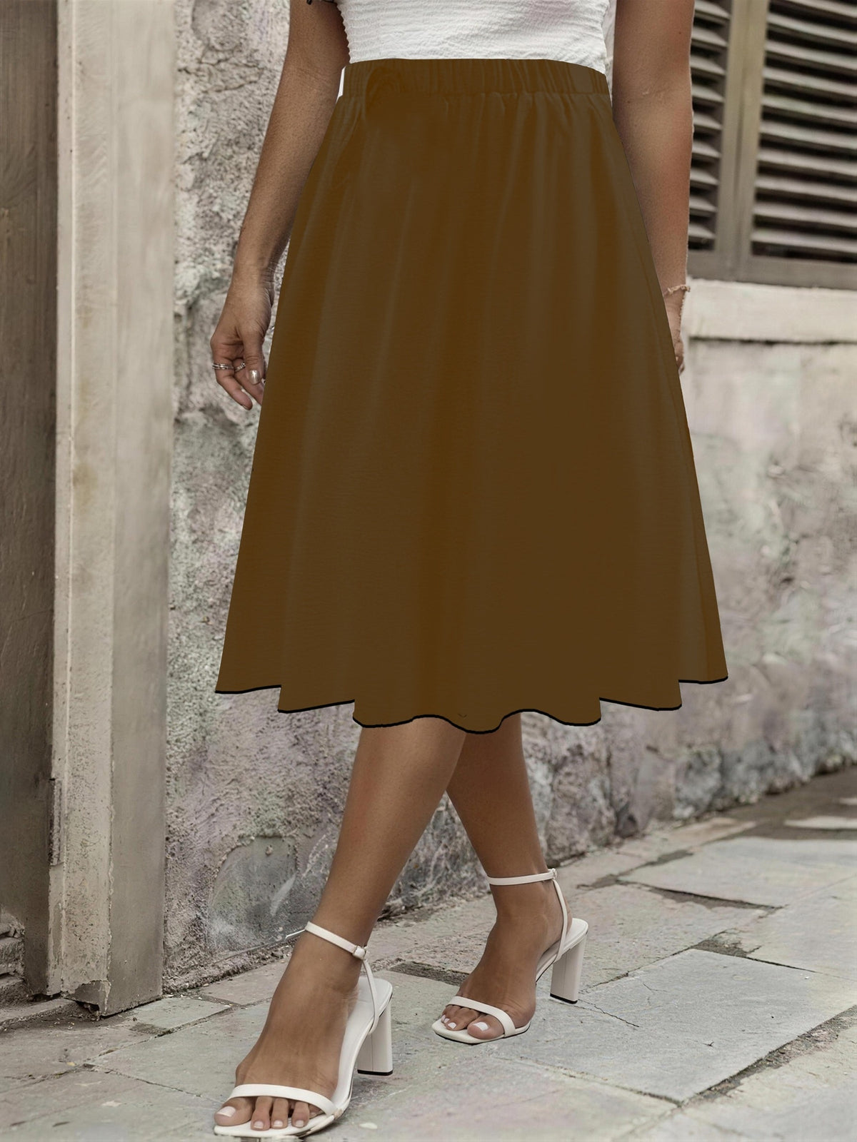 Jupe grande taille, coupe évasée, longueur genou, allure élégante, détail du tissu
