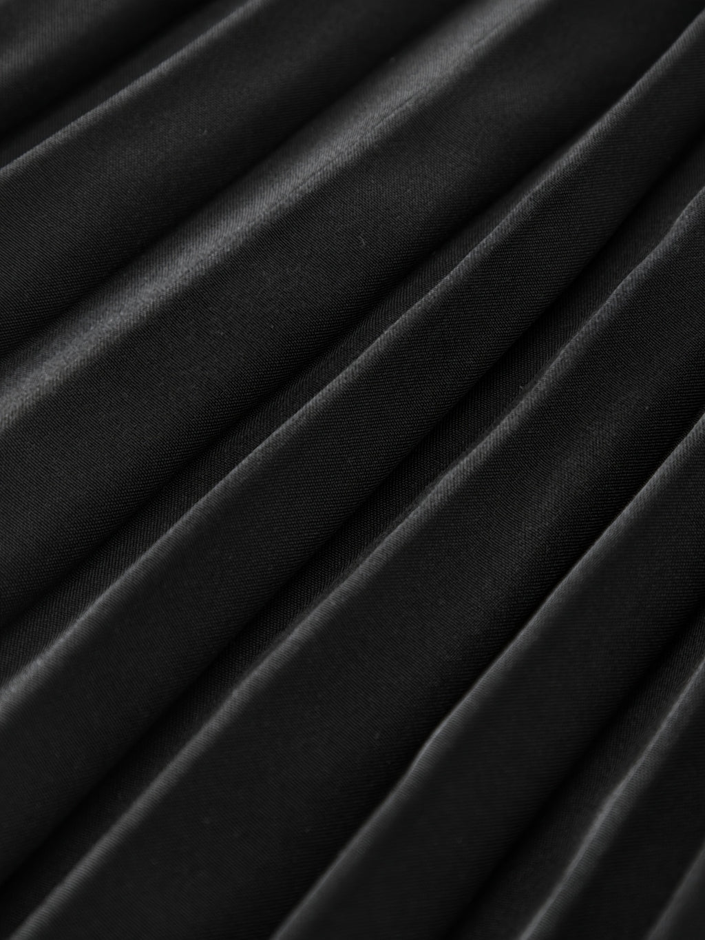 Jupe grande taille, coupe courte, plissés, détail du tissu