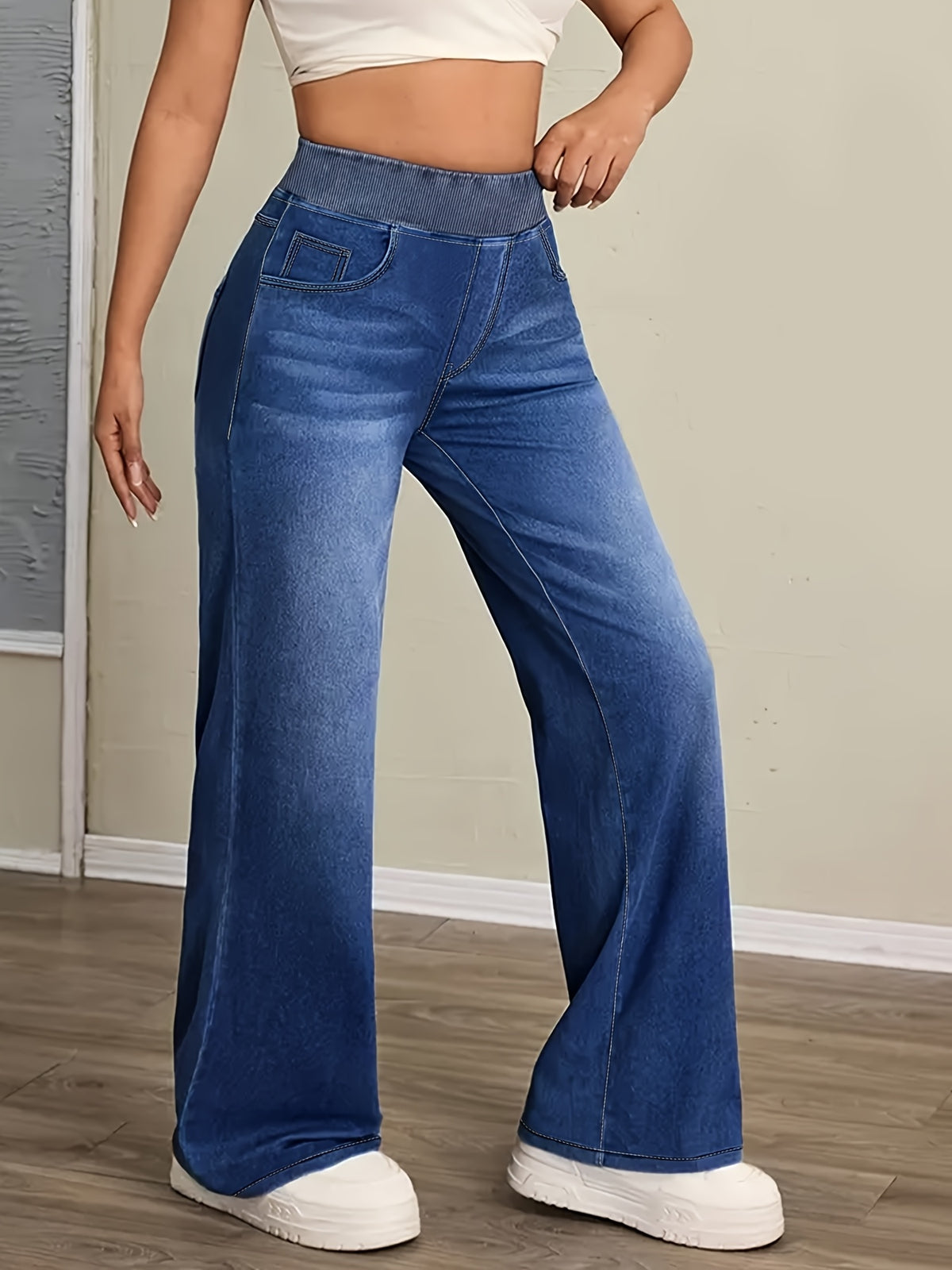 Jean grande taille, coupe évasée, délavage doux, poches pratiques, détail du tissu