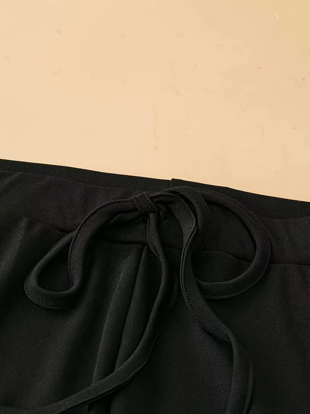 Pantalon fluide grande taille — Maille noire, ourlet ondulé