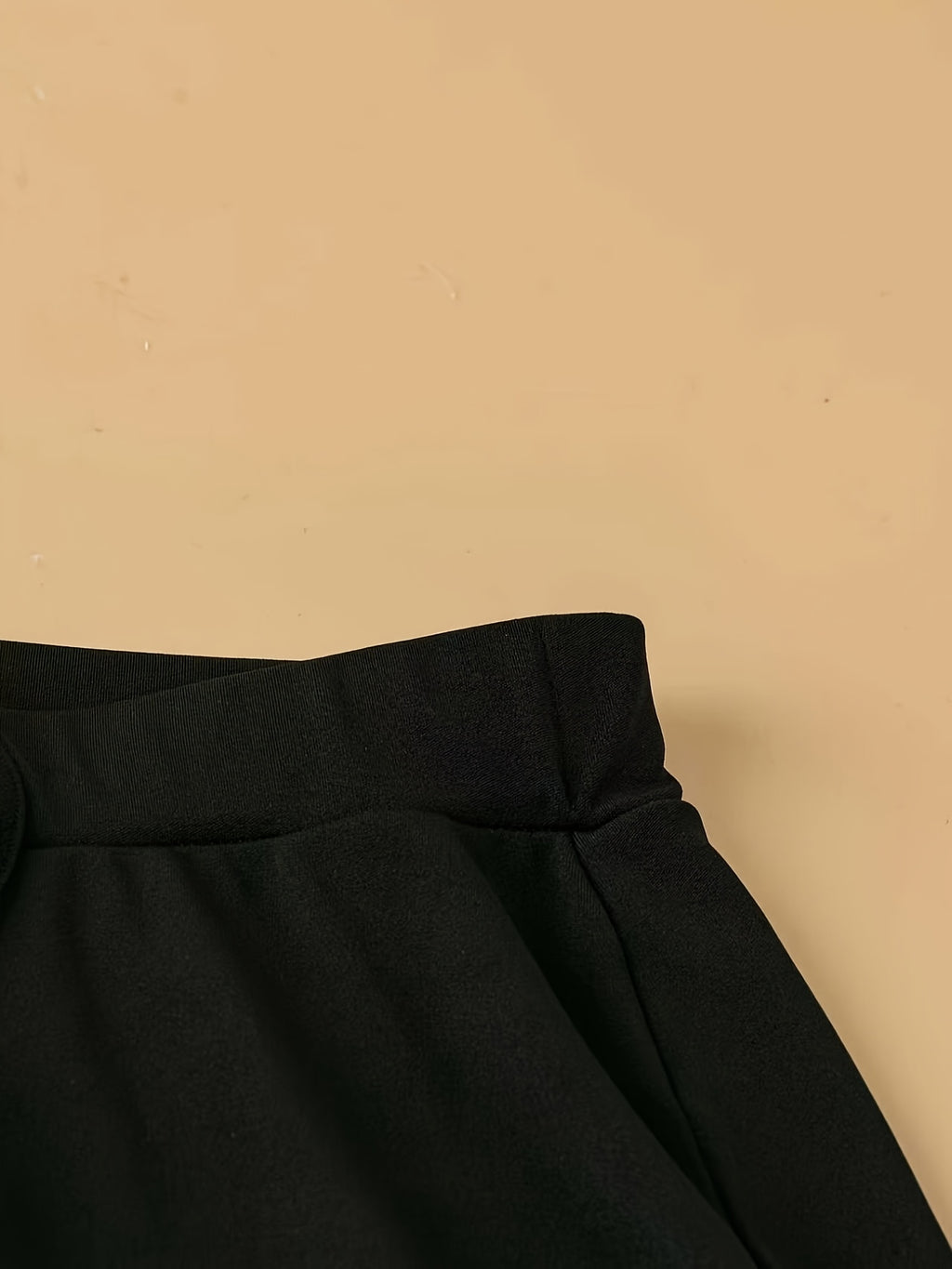 Pantalon fluide grande taille — Maille noire, ourlet ondulé